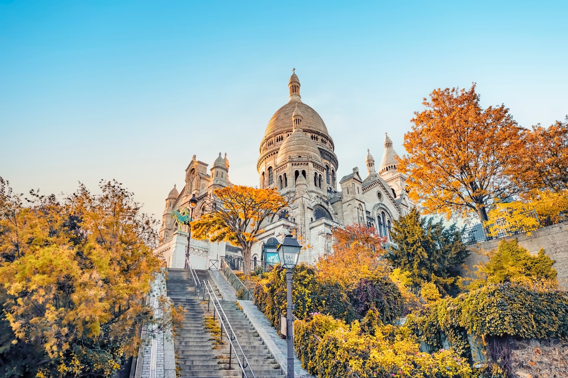 Basilique du Sacré-Cœur à Montmartre entourée d'arbres aux couleurs d'automne