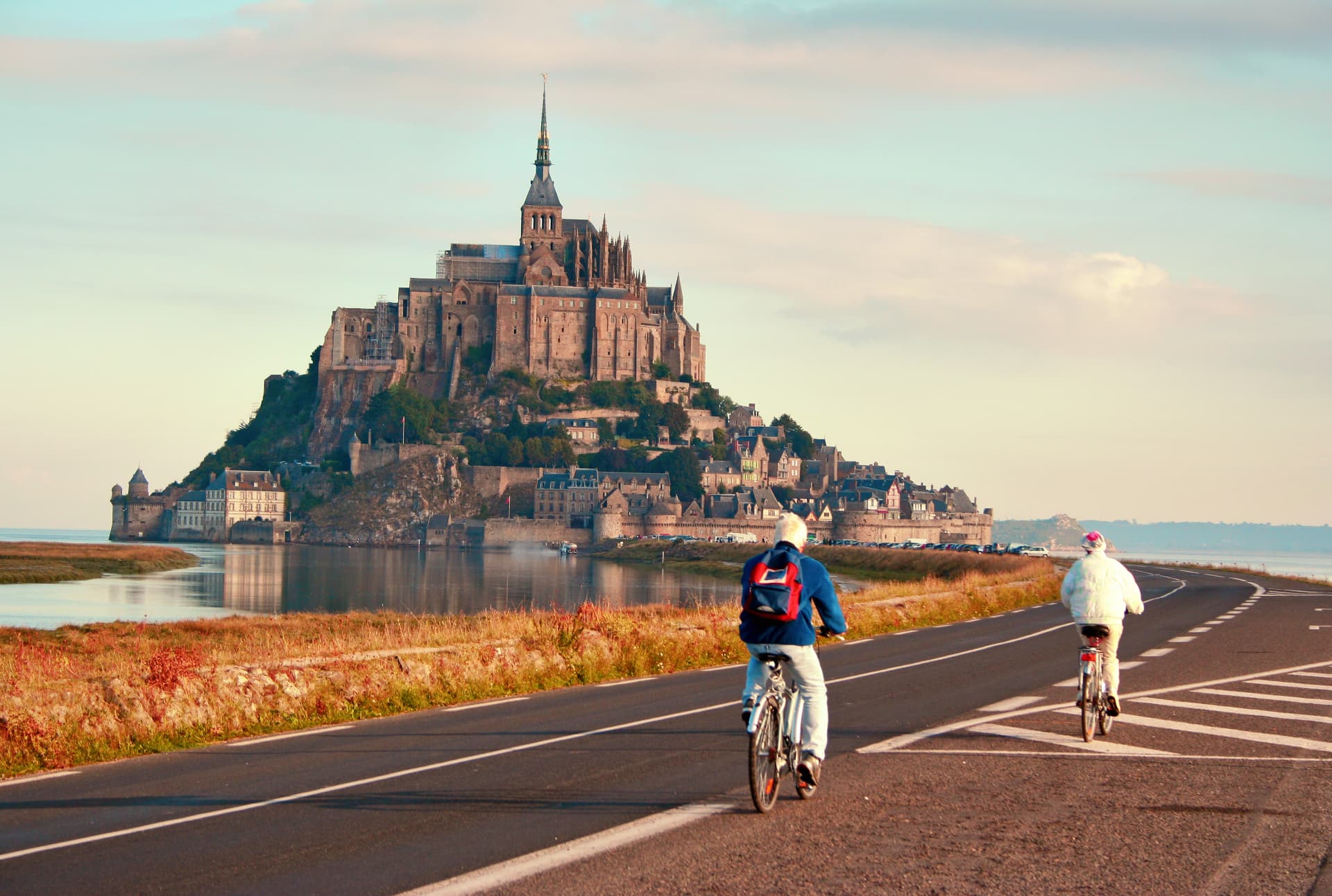 Cyclistes sur la route menant au Mont-Saint-Michel au lever du jour